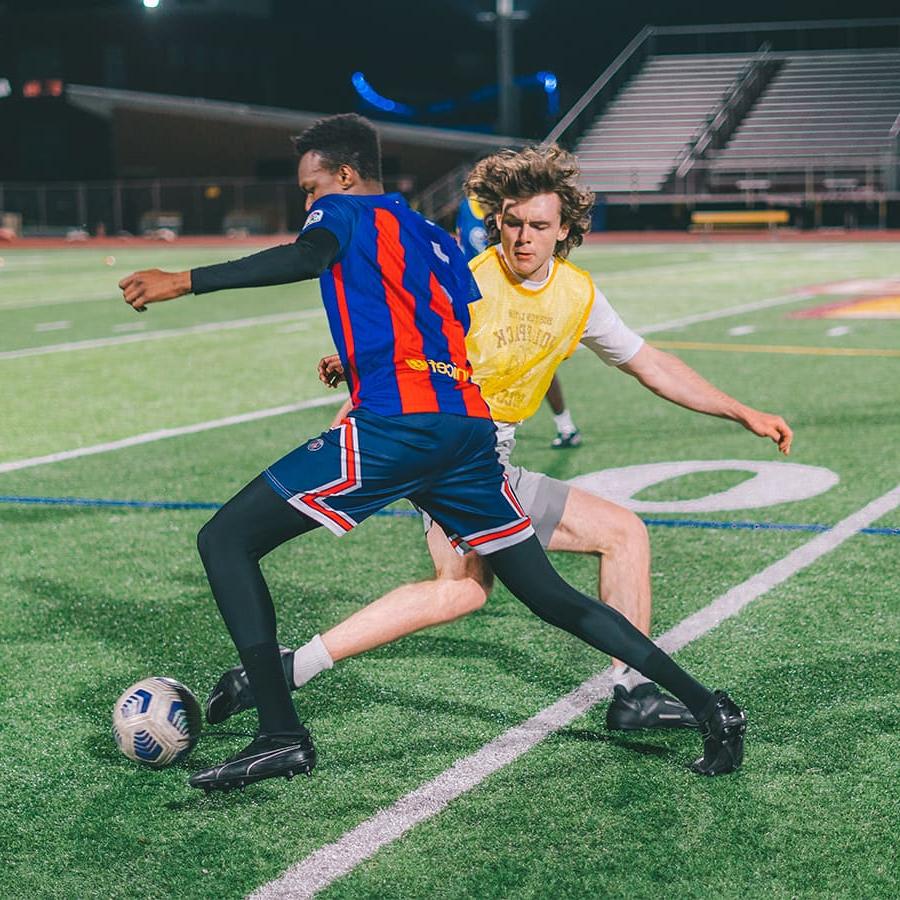 两个学生踢足球.